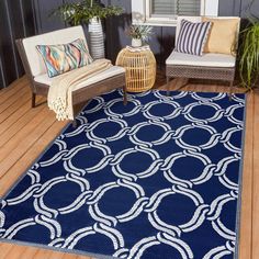 a blue area rug with white circles on it in front of a window and two wicker chairs