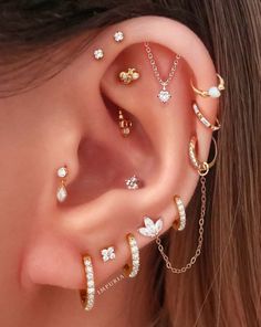 a woman wearing ear piercings with different types of jewelry on her ears and behind the ear