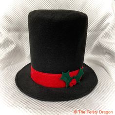 a black top hat with holly decorations on it