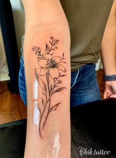 a woman's arm with a flower tattoo on the left side of her body