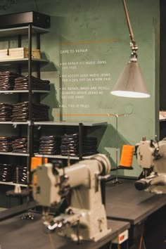 an industrial sewing machine sits in front of a wall with words on it and shelves