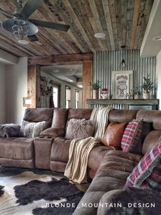 a living room filled with lots of furniture and pillows on top of a cowhide rug