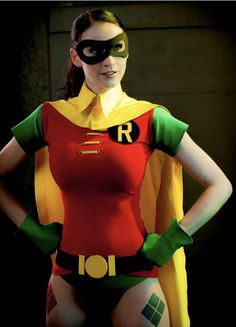 a woman in a red and yellow outfit with a green mask on her face is posing for the camera