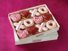 a box filled with donuts covered in frosting and pink sprinkles