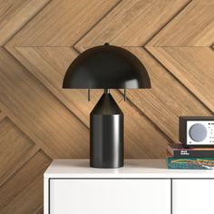 a black lamp sitting on top of a white dresser next to a wooden paneled wall