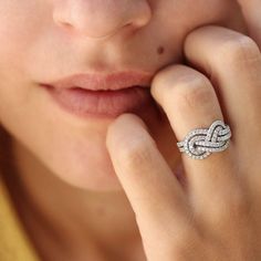 a close up of a person with a ring on their finger and her hand near her face