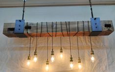 several light bulbs are hanging from a wooden beam