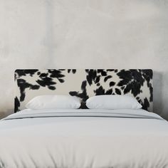 a bed with black and white headboard against a wall