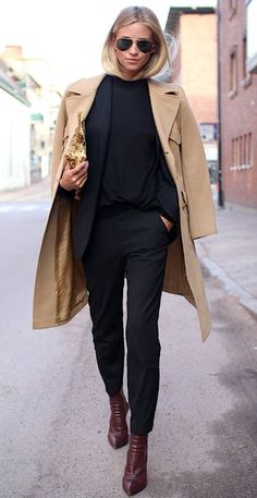 a woman walking down the street wearing a trench coat