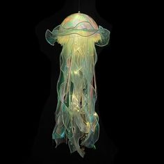 a jellyfish hanging from a ceiling in the dark with its head turned to look like it is floating