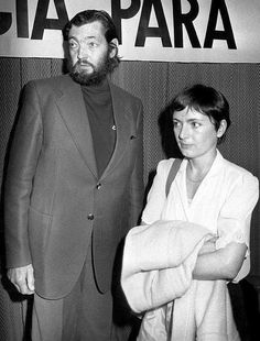 a man and woman standing next to each other in front of a sign that reads cia para