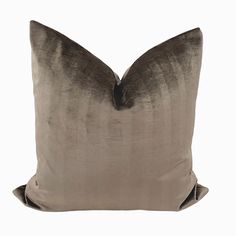 a gray and black pillow sitting on top of a white wall