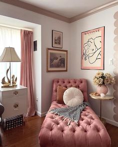 a bedroom with pink furniture and pictures hanging on the wall, along with other decor