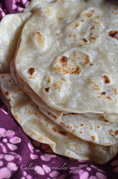 several tortillas stacked on top of each other in a purple flowered cloth