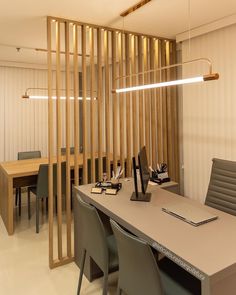 a table with chairs and a laptop on it in front of a wooden divider