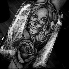 a woman with a skull and rose tattoo on her arm