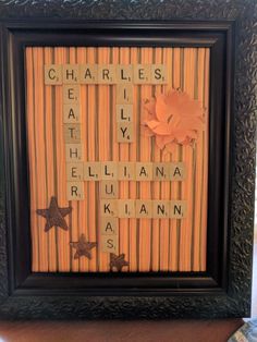 a framed scrabble art piece with words written on it and flowers in the middle