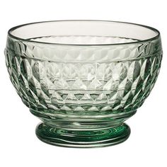 a green glass bowl sitting on top of a table