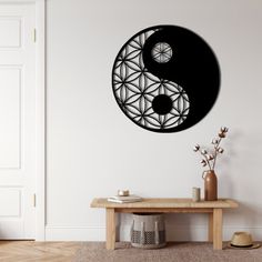 a black and white clock on the wall above a table with vases in front of it