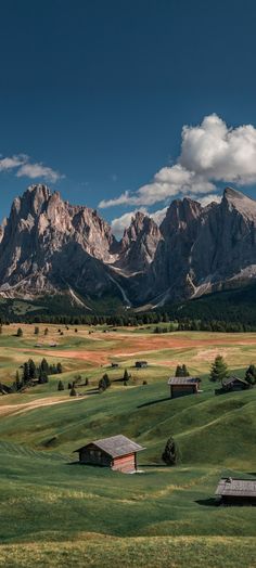 the mountains are covered in clouds and grass