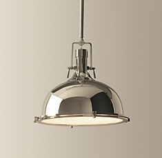 a chrome colored pendant light hanging from a ceiling