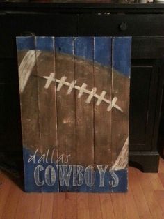 a painted wooden sign with a football on it