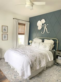 a bedroom with blue walls and white bedding