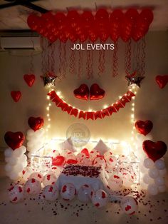 the bed is decorated with red and white balloons, heart - shaped decorations, and streamers