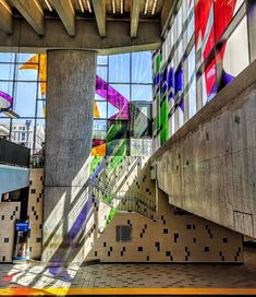 the interior of a building with many windows and colorful art on it's walls