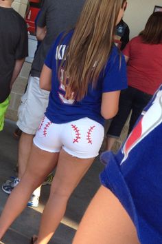 a group of people standing around each other with baseballs on their shorts in front of them