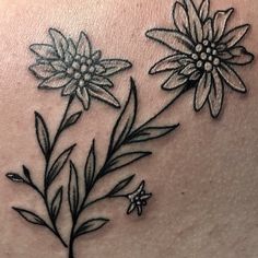 a close up of a tattoo with flowers on the back of a woman's stomach