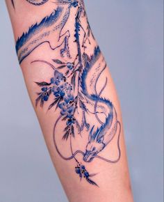 a woman's leg with tattoos on it and flowers in the middle of her legs