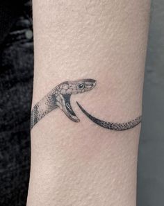 a small snake tattoo on the wrist