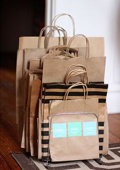 a pile of brown paper bags sitting on top of a wooden floor next to a rug