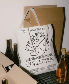 a wine bottle and two bottles of wine on a table next to a bag with the words wine - wine collection written on it