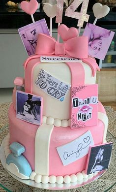 a birthday cake decorated with pink and white frosting, topped with lots of pictures