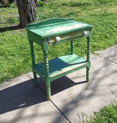 a green table sitting on top of a sidewalk