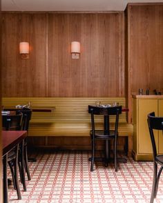 the interior of a restaurant with two tables and chairs in front of wooden paneled walls