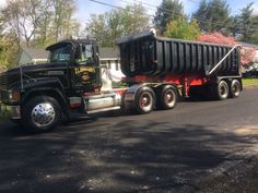 a dump truck is parked on the side of the road in front of a house