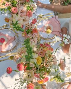 the table is set with flowers and plates