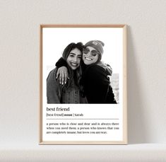 two women hugging each other in front of a white wall with the words best friend on it