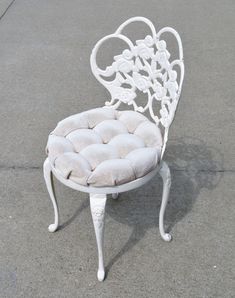 a white chair sitting on top of a cement ground