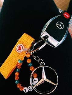 a mercedes keychain with beads and keys attached to it