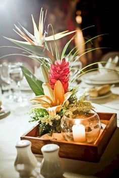 an arrangement of flowers and candles on a table