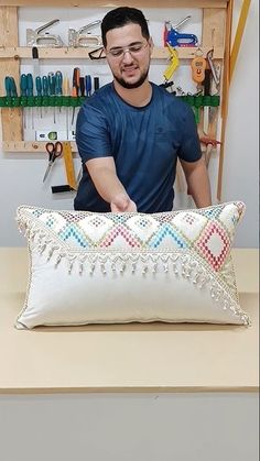 a man standing next to a pillow on top of a table