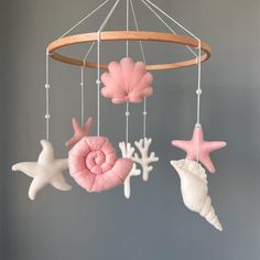 a pink and white mobile with sea shells, starfishes and seashells