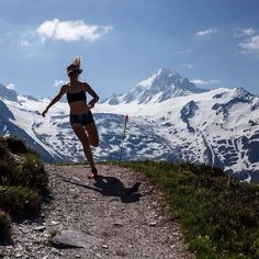 a woman running on a trail in the mountains