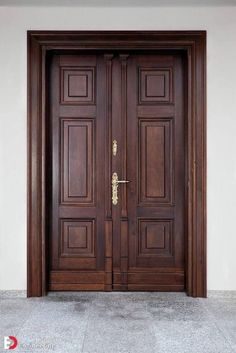 two brown wooden doors in front of a white wall