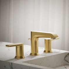 a gold faucet sitting on top of a white counter