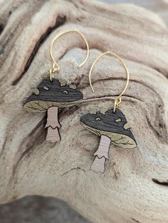 Toadstool inspired wood mushroom earrings, featuring ebony wood stain on mushroom caps with metallic gold spots and undersides, over light cherry stained stalks. Backs are not etched. Earrings hang from gold plated, nickel free hooks.  Please note that clear stoppers on hooks are for shipping stability and do not need to be worn with earrings. Ebony Wood Stain, Mushroom Caps, Boone Nc, Cherry Stain, Mushroom Earrings, Stuffed Mushroom Caps, Wood Stain, Ebony Wood, Staining Wood